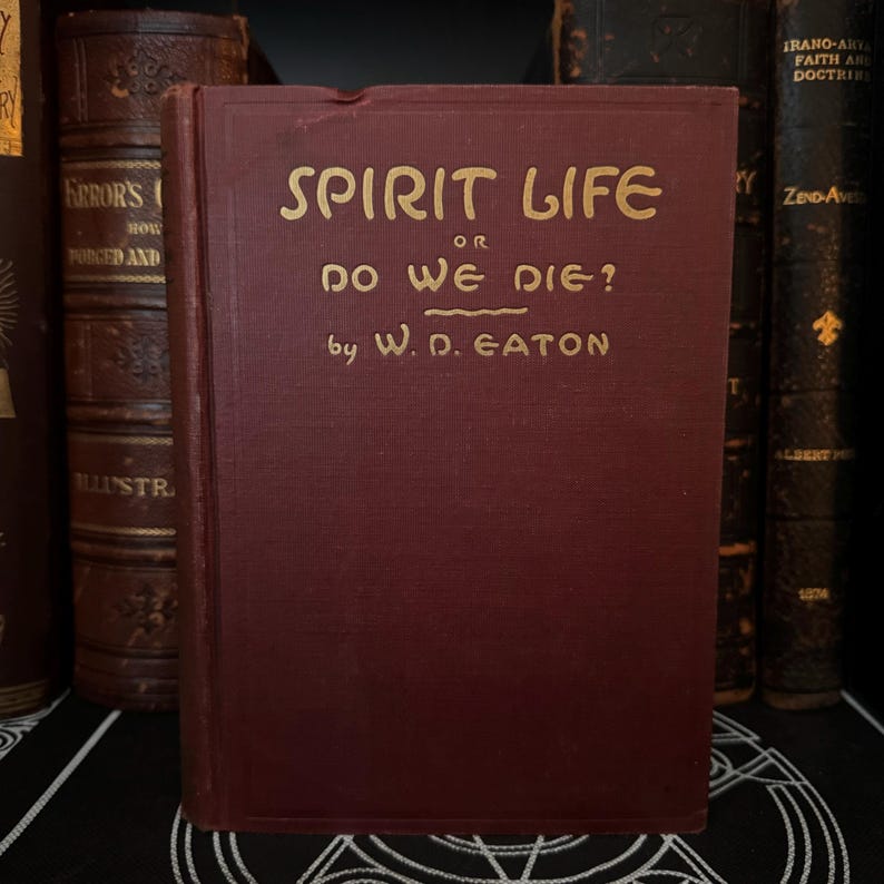 May include: A burgundy hardcover book with gold lettering on the spine and front cover. The title is "Spirit Life or Do We Die?" by W.D. Eaton.