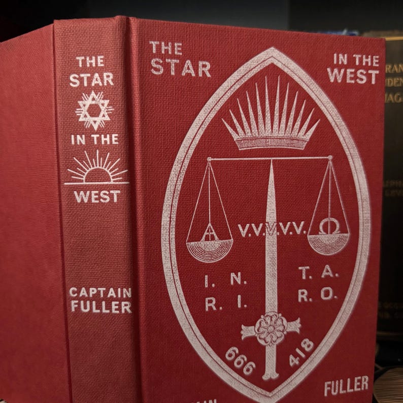 Pu&ograve; includere: Un libro rosso con un disegno bianco sulla copertina. Il titolo &egrave; "The Star in the West" e l'autore &egrave; "Captain Fuller". Il disegno presenta una corona, una bilancia, una spada e i numeri 666 e 418.
