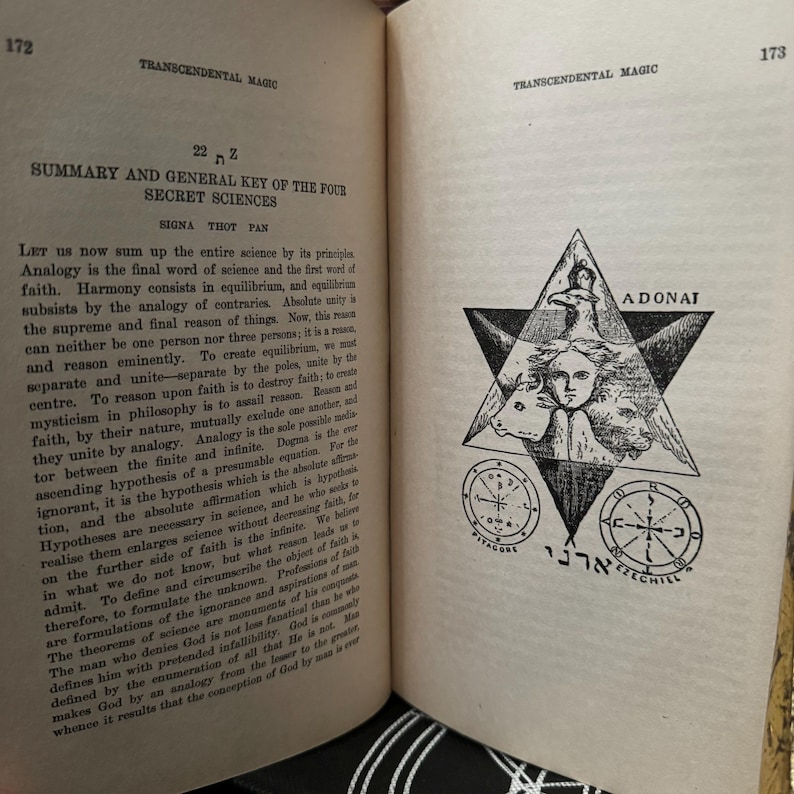 May include: A black and white illustration of a pentagram with a human figure in the centre. The figure is surrounded by a bull, a bird, and a lion. The pentagram is inscribed with the Hebrew words "Adonai" and "Zechiel".