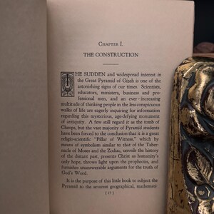 May include: A page from a book titled "The Construction" with a chapter about the Great Pyramid of Gizeh. The text discusses the widespread interest in the pyramid and its significance as a symbol of ancient wisdom.