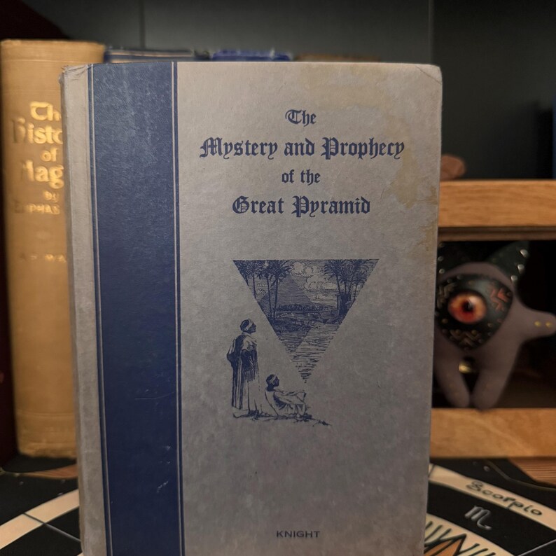 May include: A vintage book titled "The Mystery and Prophecy of the Great Pyramid" by Knight. The cover features a blue triangle with a drawing of a pyramid and two figures looking at it.