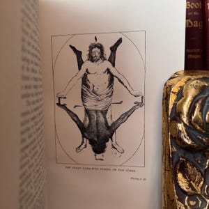 Puede incluir: Una ilustraci&oacute;n en blanco y negro de un s&iacute;mbolo cabal&iacute;stico del Zohar, un texto m&iacute;stico jud&iacute;o. La imagen representa dos figuras, una de pie y la otra boca abajo, con sus brazos y piernas entrelazados. La imagen est&aacute; rodeada por un c&iacute;rculo y un cuadrado.