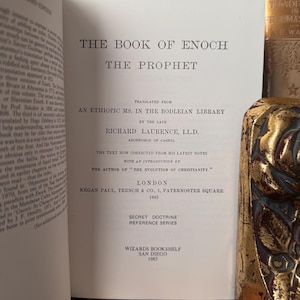 May include: Open book titled "The Book of Enoch" with text in English. The book's title and author's name are visible. The book is from the Secret Doctrine Reference Series, published in 1883 by Kegan Paul, Trench & Co. in London.