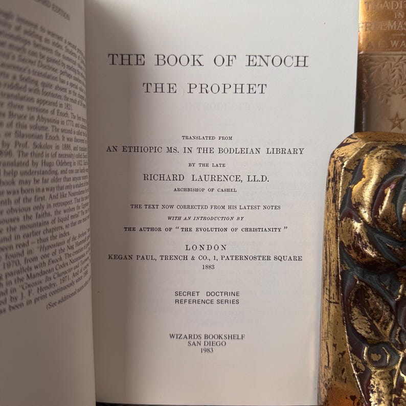 May include: Open book titled "The Book of Enoch" with text in English. The book's title and author's name are visible. The book is from the Secret Doctrine Reference Series, published in 1883 by Kegan Paul, Trench & Co. in London.