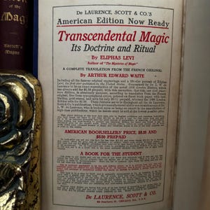 May include: A vintage book cover for "Transcendental Magic: Its Doctrine and Ritual" by Eliphas Levi. The cover features a portrait of Eliphas Levi and text about the book's contents and price. The book is a complete translation from the French original by Arthur Edward Waite.