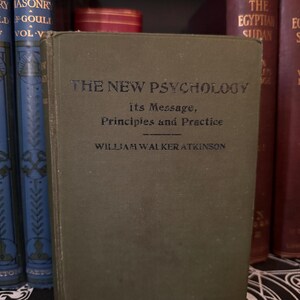 May include: A vintage green hardcover book titled "The New Psychology: Its Message, Principles and Practice" by William Walker Atkinson.
