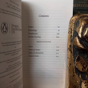 May include: Open book with a table of contents, including "Preface," "Chronology," and "Introduction." The book is published by Penguin Random House UK. A decorative gold object is visible on the right side of the image.