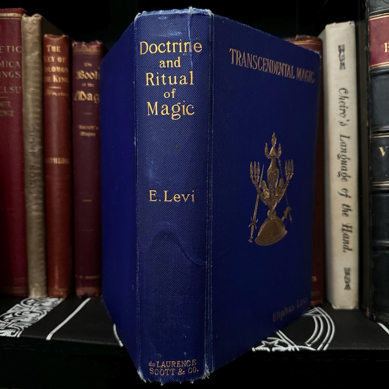 May include: A blue hardback book titled "Doctrine and Ritual of Magic" by E. Levi. The book cover features a gold illustration of a figure with a crown and a staff.