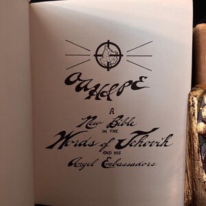 Pu&ograve; includere: Pagina di libro aperta con il titolo "Our Hope" in scrittura stilizzata, con un emblema a forma di foglia all'interno di un cerchio. Sotto, il testo recita "A New Bible in the Words of Jehovah and His Angel Ambassadors."