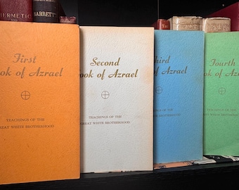 Puede incluir: Una colección de libros antiguos con cubiertas coloridas. Los libros se titulan "First Book of Azrael", "Second Book of Azrael", "Third Book of Azrael" y "Fourth Book of Azrael". Cada libro tiene un color único: naranja, blanquecino, azul y verde.