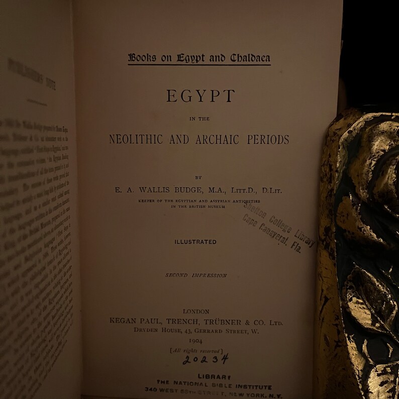 May include: A book titled "Egypt in the Neolithic and Archaic Periods" by E.A. Wallis Budge, M.A., Litt.D., D.Litt. The book is illustrated and is the second impression. It was published in London by Kegan Paul, Trench, Tr&uuml;bner & Co. Ltd. in 1904. The book is from the library of the National Bible Institute in New York.