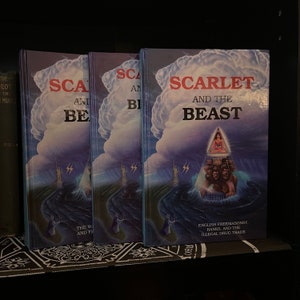 Könnte beinhalten: Drei Bücher mit dem Titel "Scarlet and the Beast", "Scarlet and the Beast" und "Scarlet and the Beast". Der Einband der Bücher zeigt einen dunkelblauen Himmel mit einer weißen Wolke, eine große Pyramide mit einer darauf sitzenden Frau und ein Gewässer mit der Freiheitsstatue im Hintergrund. Der Text auf dem Einband lautet "Scarlet and the Beast" und "Englische Freimaurerei, Banken und illegaler Drogenhandel".
