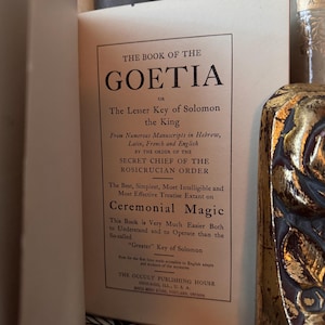 Op de afbeelding: Open boek met de titel "The Book of the Goetia" en de ondertitel "The Lesser Key of Solomon the King". De tekst beschrijft de inhoud van het boek over ceremoni&euml;le magie, afkomstig van Hebreeuwse, Latijnse, Franse en Engelse manuscripten.