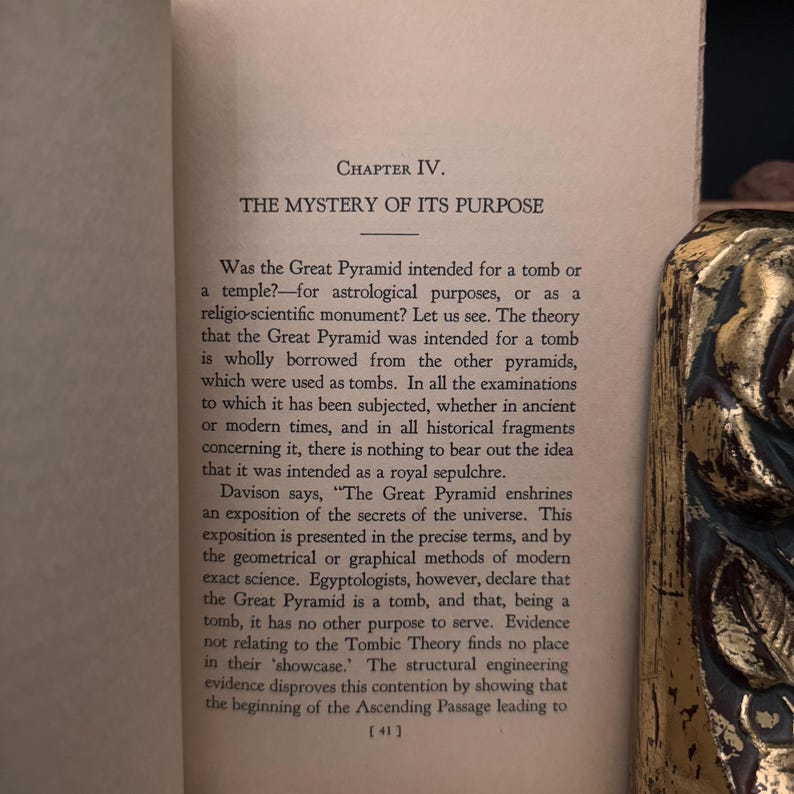 May include: A page from a book titled "The Mystery of Its Purpose" discussing the Great Pyramid of Giza. The text discusses the theory that the pyramid was intended for a tomb, but argues that it was actually a royal sepulchre.