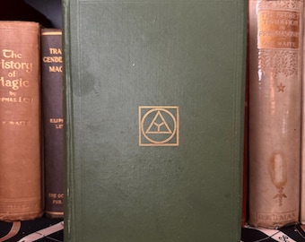 Könnte beinhalten: Ein grünes Hardcover-Buch mit einem goldenen Dreiecksymbol auf dem vorderen Umschlag. Das Buch trägt den Titel "The Secret Tradition in Freemasonry" von A.E. Waite.