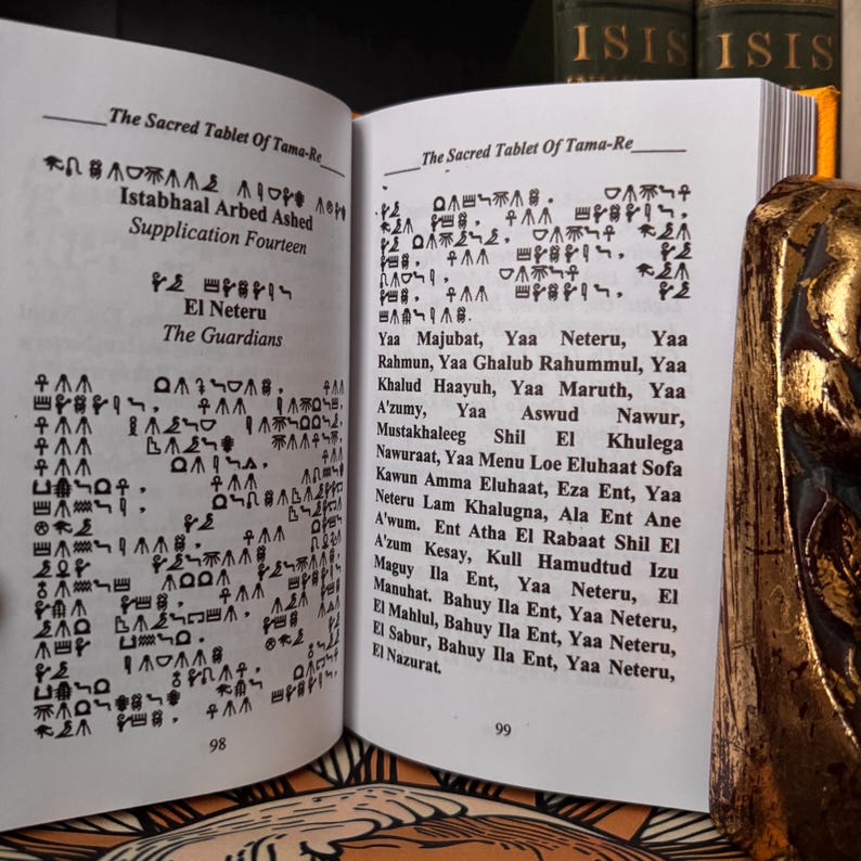 May include: An open book with pages displaying ancient text and symbols. The text is in black ink on aged paper. The book is titled "The Sacred Tablet of Tama-Re" and includes the text "El Neteru The Guardians".