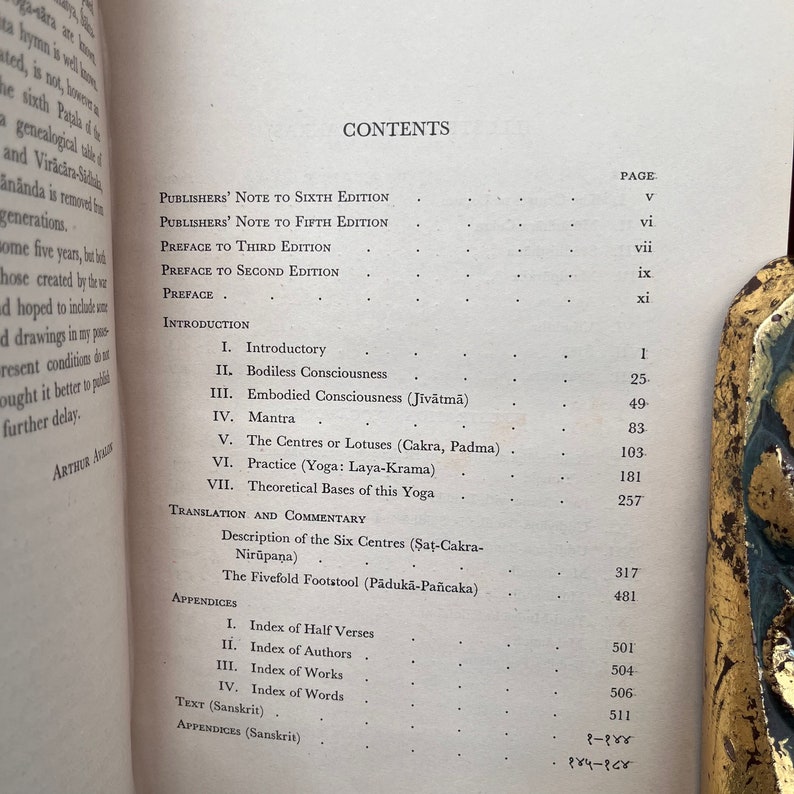 May include: A book titled "The Centres of Lotus" with a table of contents listing chapters and page numbers. The book covers topics such as Bodiless Consciousness, Embodied Consciousness, Mantra, and Practice (Yoga: Laya-Krama).