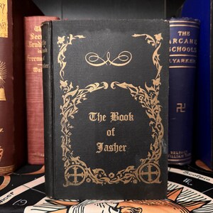 Pode incluir: Um livro preto com letras douradas e bordas decorativas. O título do livro é "The Book of Jasher".