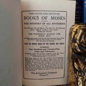 May include: A vintage book titled "The Sixth and Seventh Books of Moses: The Mystery of All Mysteries" with a black and white cover. The book contains 125 seals and talismans translated from the German original, word for word, according to the old ancient writings and famous manuscripts of the Hebrews.