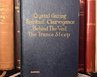 May include: A blue hardcover book with gold lettering on the spine and front cover. The title is "Crystal Gazing Spiritual Clairvoyance Behind The Veil The Trance Sleep" by "de LAFRENCE".