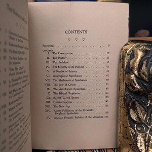 May include: A book titled "The Great Pyramid" with a table of contents listing chapters on the construction, history, builders, mystery of its purpose, and more. The book is printed on white paper with black text.