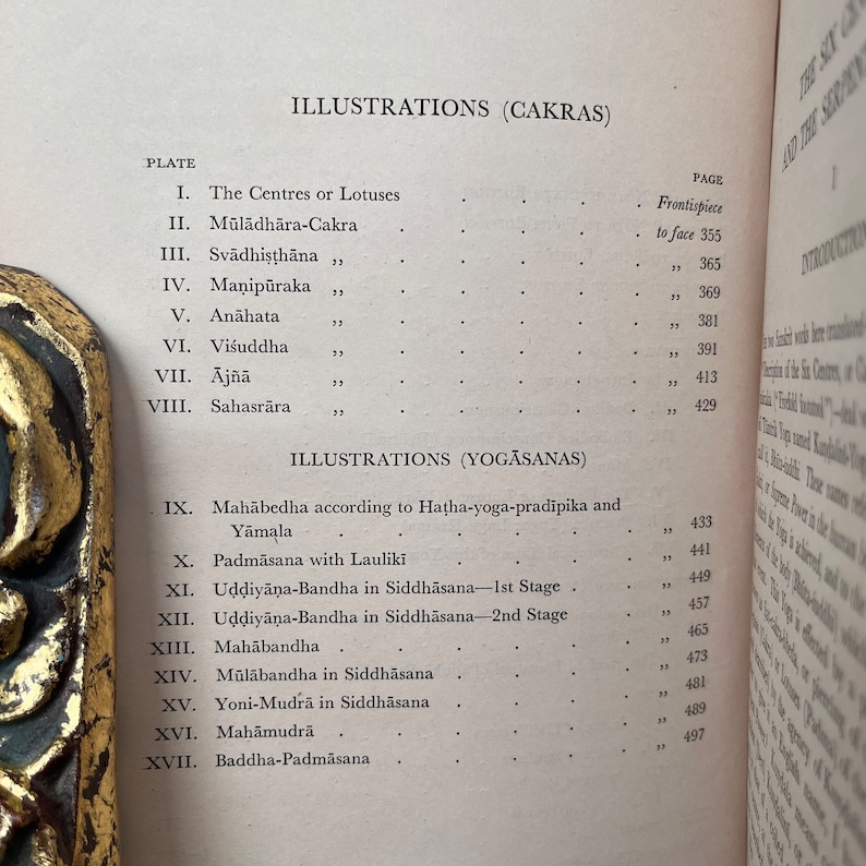 May include: A black and white book with the title "Illustrations (Cakras)" and "Illustrations (Yogasanas)" on the cover. The book lists different plates and pages for each illustration.