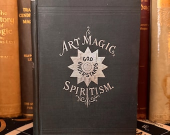 May include: A black book with silver lettering on the cover. The title is "Art Magic Spiritism." The cover also features a silver star with the words "God Understands" inside.