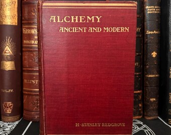 May include: A red hardback book titled "Alchemy Ancient and Modern" by H-Stanley Redgrove.
