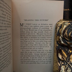 May include: A vintage book with a yellowed page open to a chapter titled "Reading the Future". The text describes a young man named George Brown who is seeking a fortune teller.