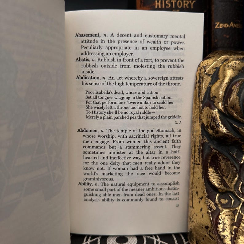 May include: A page from a vintage book titled "History" with a black and white illustration of a woman in a long dress. The page contains definitions of words like "Abasement", "Abatis", "Abdication", "Abdomen", and "Ability".