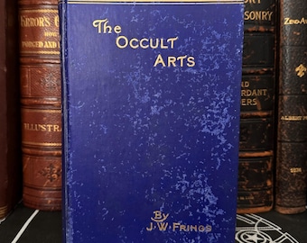 May include: A blue hardcover book titled "The Occult Arts" by J.W. Frings. The book is worn and has a speckled texture.