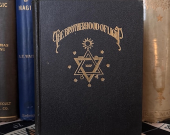 May include: A black book with gold lettering on the cover. The title is "The Brotherhood of Light" and there is a six-pointed star with a sun above it.