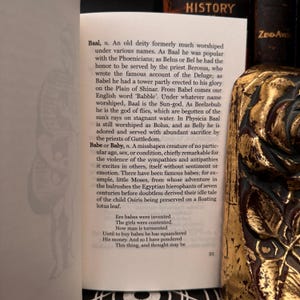 May include: A page from a book titled "History" with text about the deity Baal and the word "Babe or Baby". The text describes the deity Baal as a sun god and the word "Babe or Baby" as a misshapen creature. The text also includes a poem about babies.