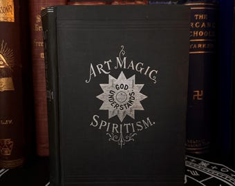 May include: A black book with silver lettering on the cover. The title is "Art Magic Spiritism." The cover also features a silver star with the words "God Understands" inside.