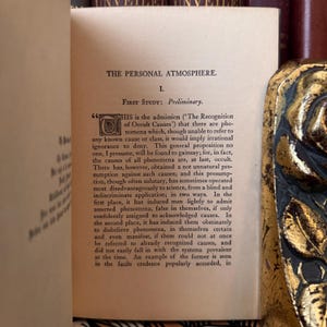 Puede incluir: Libro abierto con el t&iacute;tulo "THE PERSONAL ATMOSPHERE." La p&aacute;gina muestra texto con el encabezado "FIRST STUDY: Preliminary." El texto trata sobre el reconocimiento de causas y fen&oacute;menos ocultos.