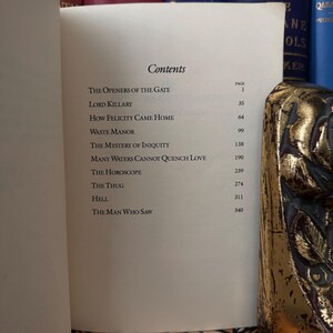 以下が含まれることがあります： 白い表紙と黒い文字の書物。本のタイトルは「Contents」。本書は各章の章とページ番号をリストアップしています。章には、「The Openers of the Gate」、「Lord Killary」、「How Felicity Came Home」、「Waste Manor」、「The Mystery of Iniquity」、「Many Waters Cannot Quench Love」、「The Horoscope」、「The Thug」、「Hell」、「The Man Who Saw」が含まれています。