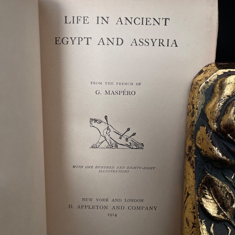 以下が含まれることがあります： G. マスペロ著「古代エジプトとアッシリアの生活」というタイトルの本の表紙。表紙には、矢が突き出ている生き物の白黒のイラストが描かれている。