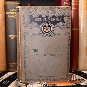 Pu&ograve; includere: Un libro vintage intitolato "The Occult World" della "Occult Series" con un simbolo di stella di David dorata sulla copertina.