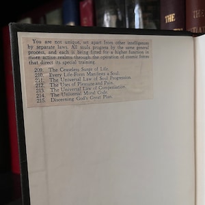 May include: A close-up of a book page with a white background and black text. The text discusses the progression of souls and the operation of cosmic forces. The page numbers are 209 through 215.
