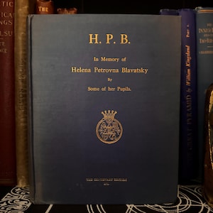 Könnte beinhalten: Ein blaues Hardcover-Buch mit goldenen Lettern auf dem vorderen Umschlag. Der Titel lautet "H.P.B." und der Untertitel lautet "In Gedenken an Helena Petrovna Blavatsky" von "Einige ihrer Schüler."