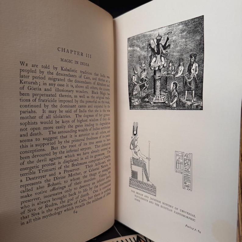 Puede incluir: Una ilustraci&oacute;n en blanco y negro de una p&aacute;gina de libro con texto sobre la magia en la India. El texto trata sobre los descendientes de Ca&iacute;n y las tradiciones originales de fratricidio. La p&aacute;gina tambi&eacute;n incluye dos ilustraciones en blanco y negro de figuras con vestimenta tradicional.