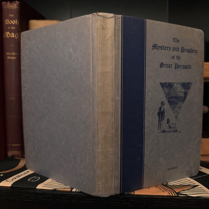 May include: A blue and gray hardcover book with the title "The Mystery and Prophecy of the Great Pyramid" on the cover. The cover also features a black and white illustration of a pyramid and two figures.