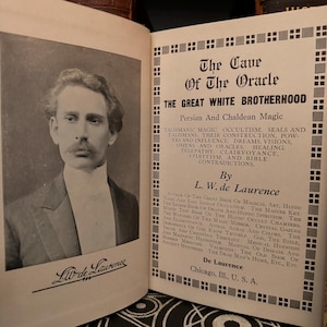 May include: A black and white photograph of a man with a moustache and a white collared shirt. The text on the page reads "The Cave of The Oracle" and "The Great White Brotherhood". The text also includes "Persian and Chaldean Magic" and "By L.W. de Laurence".