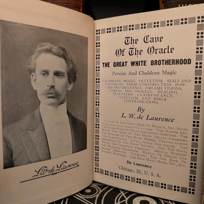 May include: A black and white photograph of a man with a moustache and a white collared shirt. The text on the page reads "The Cave of The Oracle" and "The Great White Brotherhood". The text also includes "Persian and Chaldean Magic" and "By L.W. de Laurence".