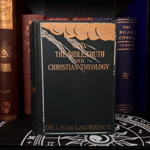 May include: A vintage green hardback book with gold lettering titled "God, The Bible, Truth and Christian Theology" by Dr. L.W. de Laurence.