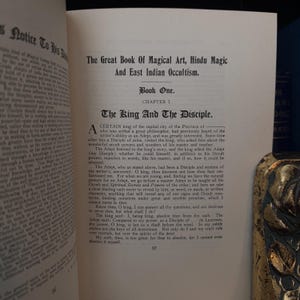 Pu&ograve; includere: Una pagina di un libro vintage intitolato "Il Grande Libro dell'Arte Magica, Magia Indu e Occultismo Indiano Orientale." La pagina presenta un capitolo intitolato "Il Re e il Discepolo." Il testo tratta della relazione tra un re e un discepolo di un'arte magica.