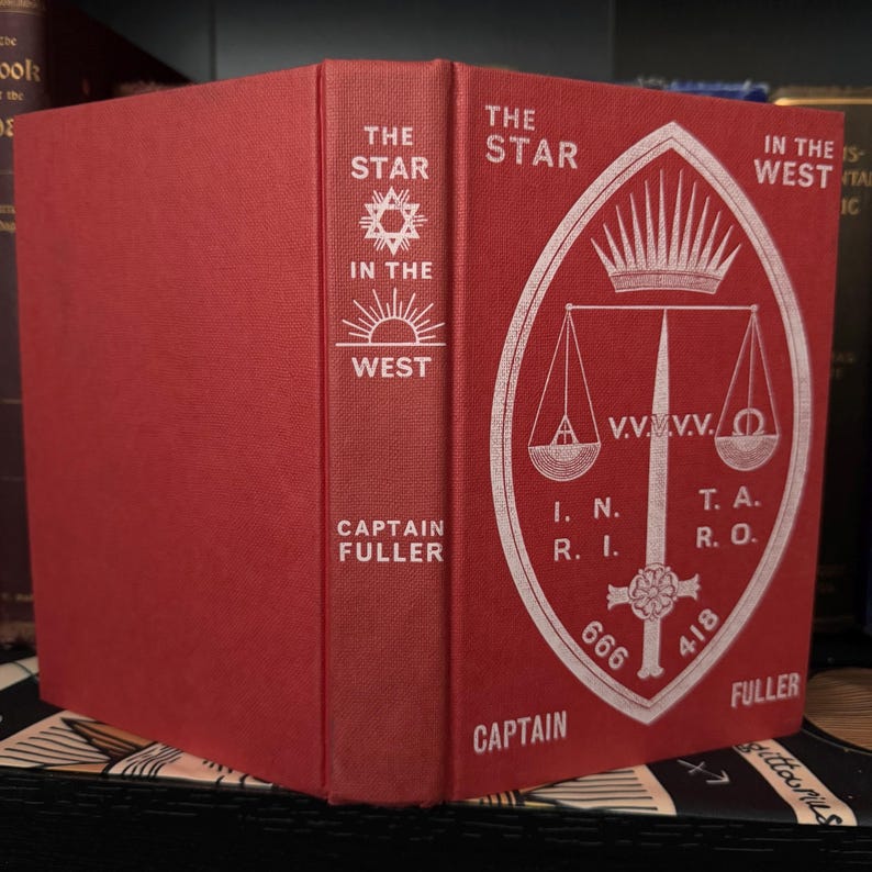 Pu&ograve; includere: Un libro rilegato in rosso intitolato "The Star in the West" di Captain Fuller. La copertina presenta una stella bianca con un sole che sorge alle sue spalle e una bilancia con una spada e una corona.