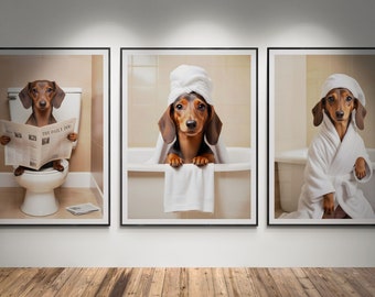 May include: Three framed prints of a dachshund dog in a bathroom setting. The first print shows the dog sitting on a toilet reading a newspaper titled "The Daily Dog". The second print shows the dog in a bathtub with a towel wrapped around its head. The third print shows the dog wearing a white bathrobe.