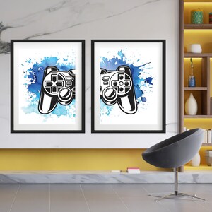 May include: Two framed prints of a black and white video game controller on a blue watercolour background. The controller is partially visible in each print.