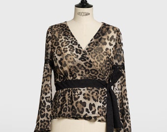 May include: A brown and black leopard print blouse with a black tie belt and long bell sleeves.